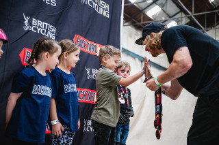 Greg Illingworth awarding medals to riders at an indoor venue in the UK.