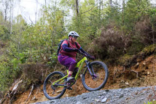 A mountain biker cycling up a forest gravel climb