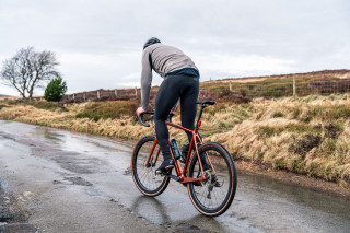 A road rider going uphill on a winter moorland lane