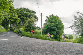 Rour road riders rounding a corner