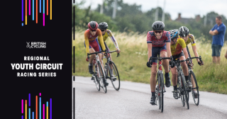 Youth males racing on a wet circuit, with event branding added to the left